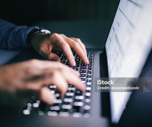 Close up of hands typing on laptop. Night work concept.